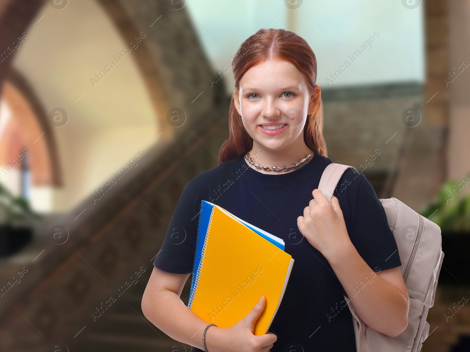 Image of Teenage student with notebooks and backpack in college