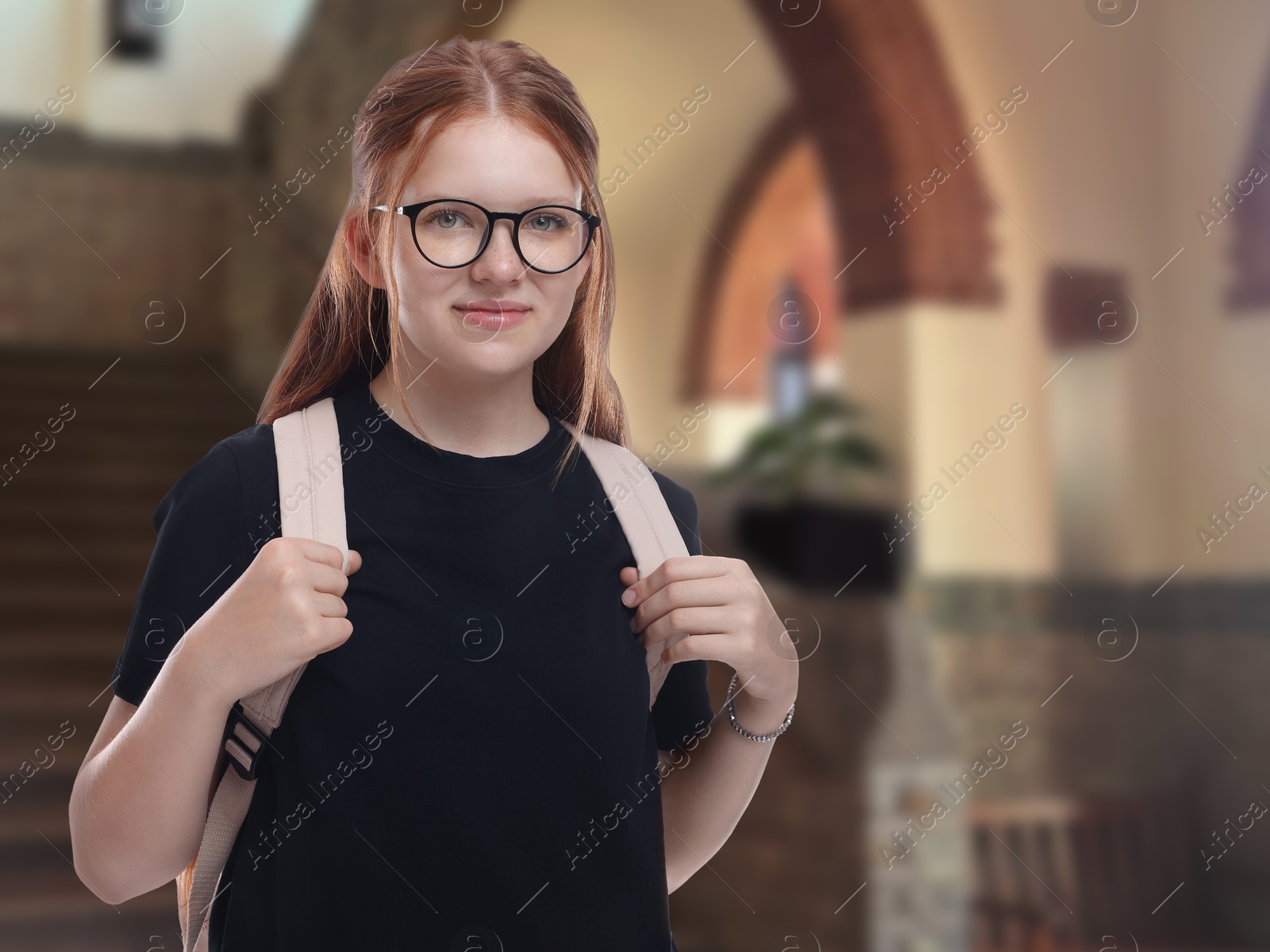 Image of Teenage student with eyeglasses and backpack in college