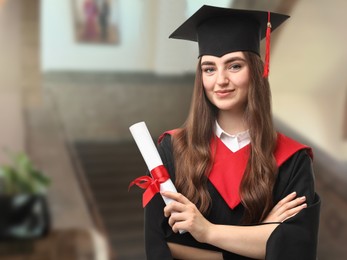 Image of Happy student in academic dress holding diploma after graduation in university