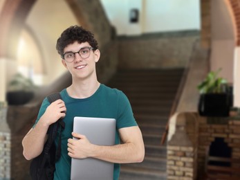 Image of Teenage student with eyeglasses, laptop and backpack in college