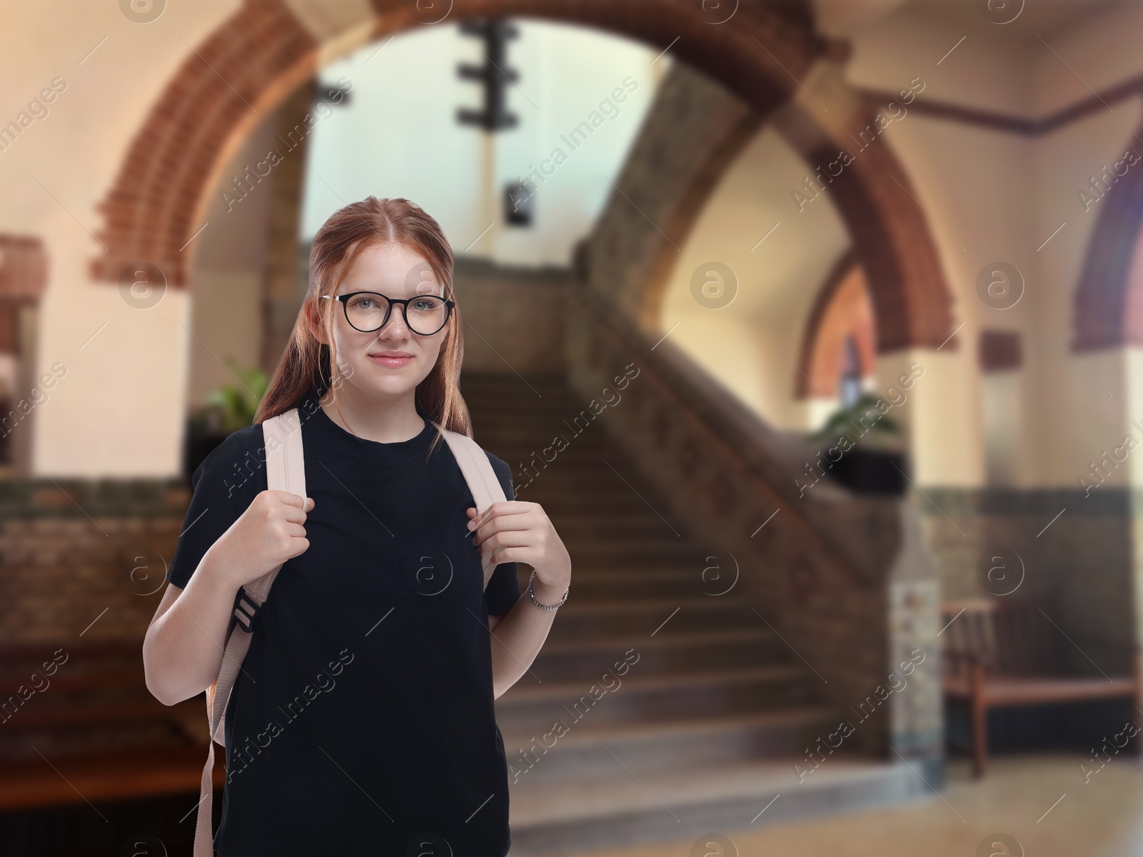 Image of Teenage student with eyeglasses and backpack in college