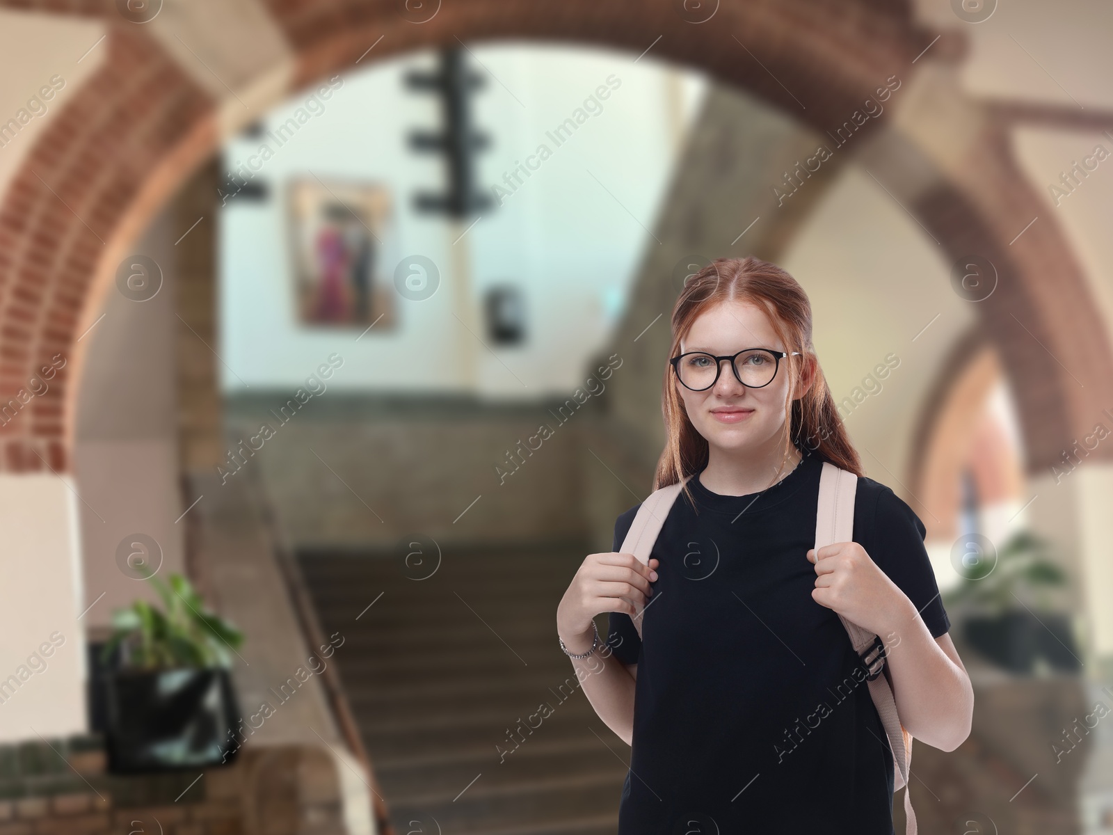 Image of Teenage student with eyeglasses and backpack in college