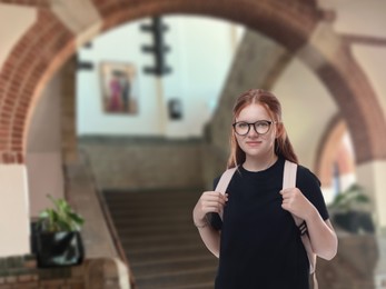 Image of Teenage student with eyeglasses and backpack in college