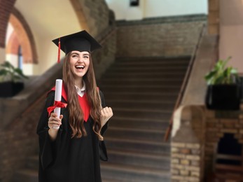 Image of Happy student in academic dress holding diploma after graduation in university