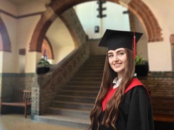 Image of Happy student wearing academic dress during graduation in university