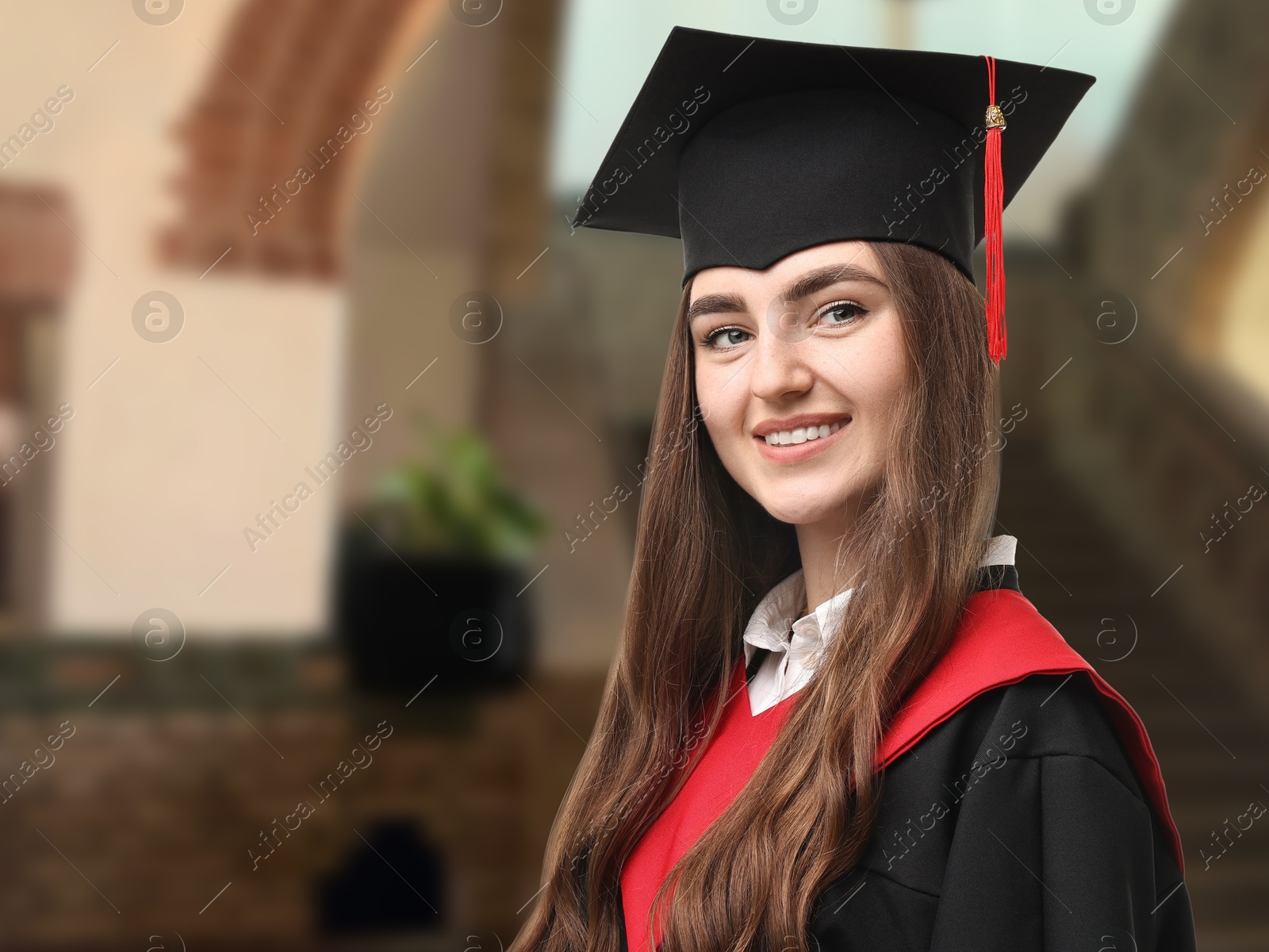 Image of Happy student wearing academic dress during graduation in university