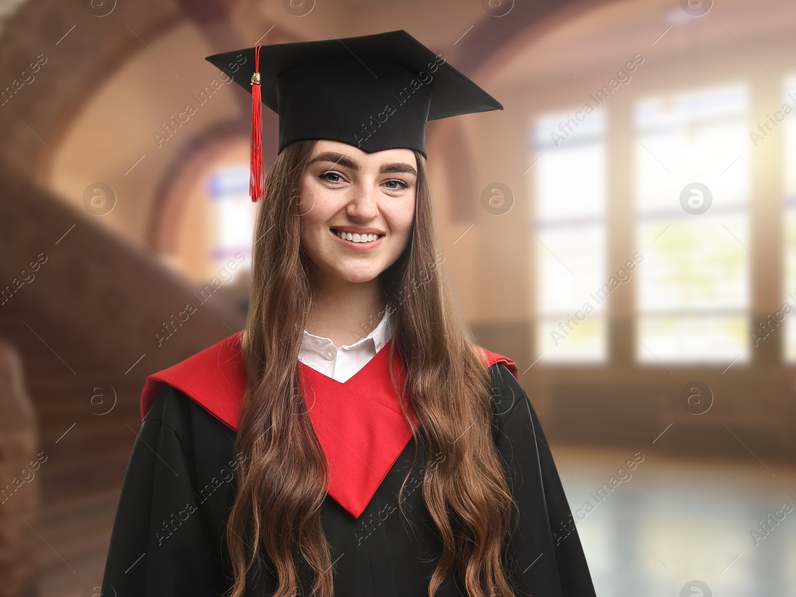 Image of Happy student wearing academic dress during graduation in university