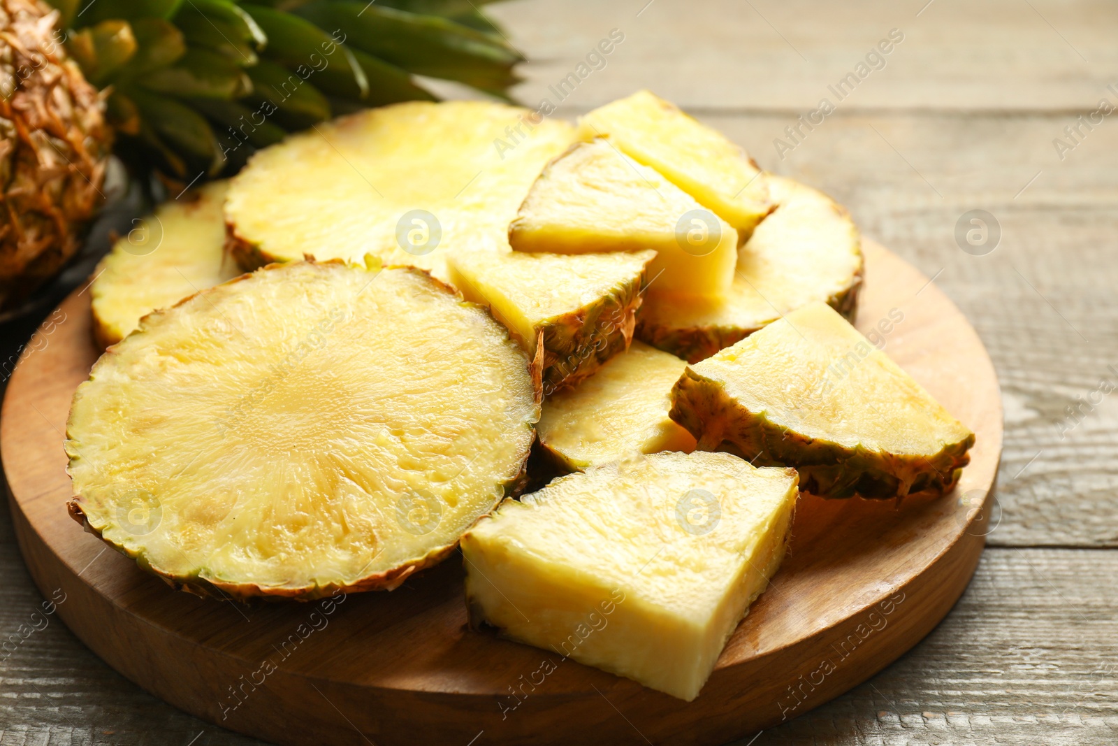 Photo of Slices of ripe pineapple on wooden table, closeup