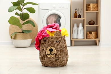 Photo of Wicker basket full of laundry in bathroom