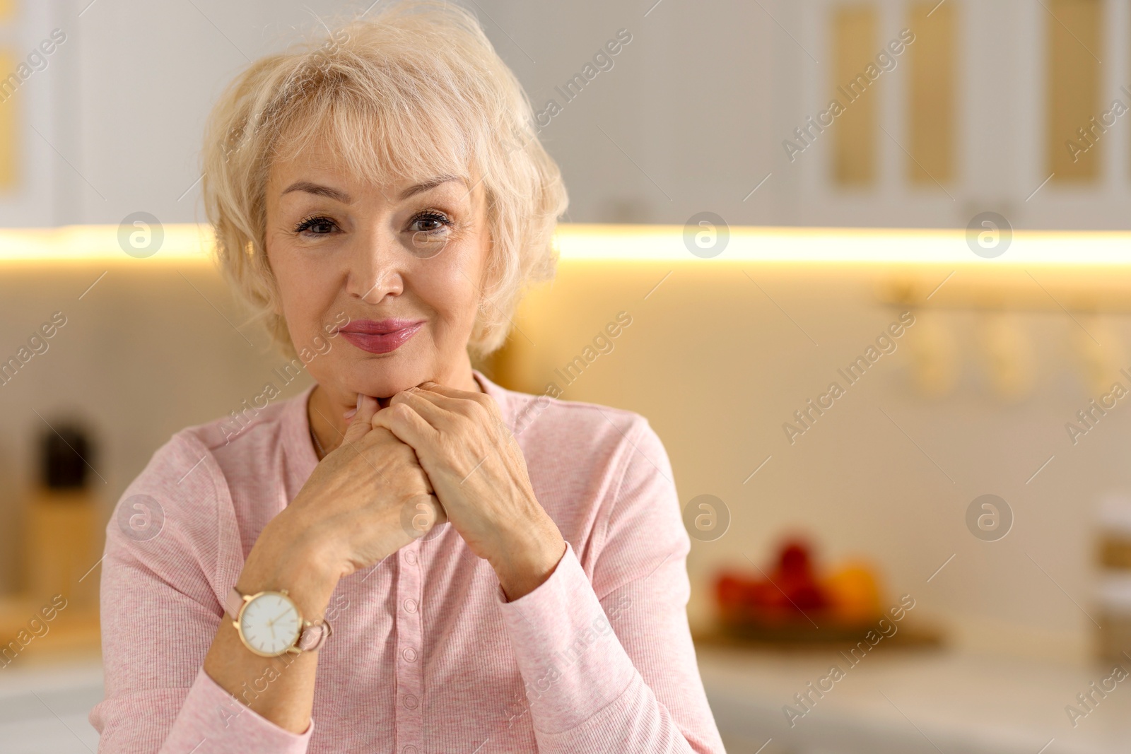 Photo of Portrait of beautiful grandmother in kitchen. Space for text