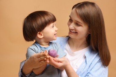 Photo of Mother and baby eating tasty mochi on brown background