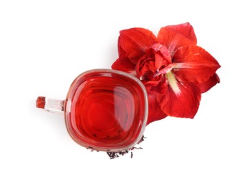 Photo of Tasty hibiscus tea in glass cup and flower isolated on white, top view