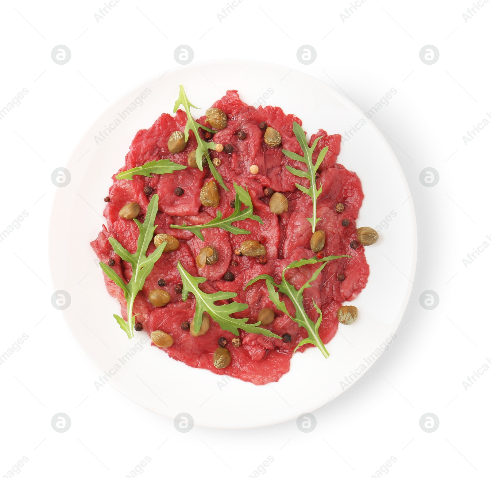 Photo of Fresh beef carpaccio with arugula and capers isolated on white, top view