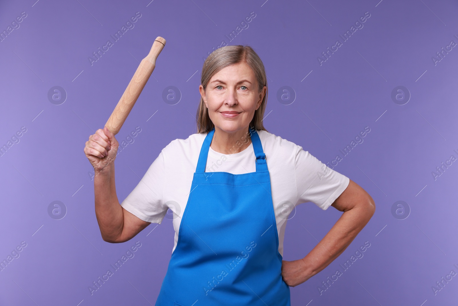 Photo of Woman with rolling pin on violet background