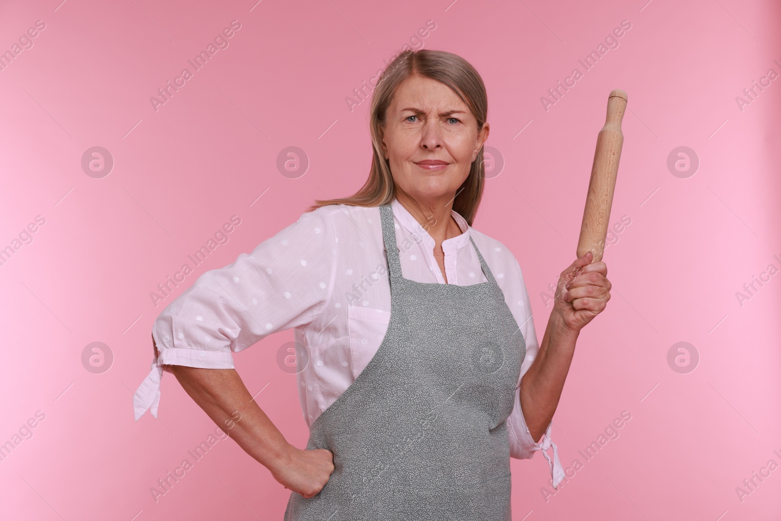 Photo of Woman with rolling pin on pink background