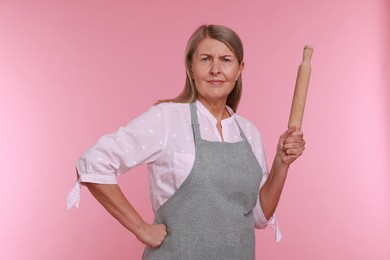 Photo of Woman with rolling pin on pink background