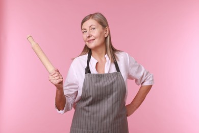 Photo of Woman with rolling pin on pink background