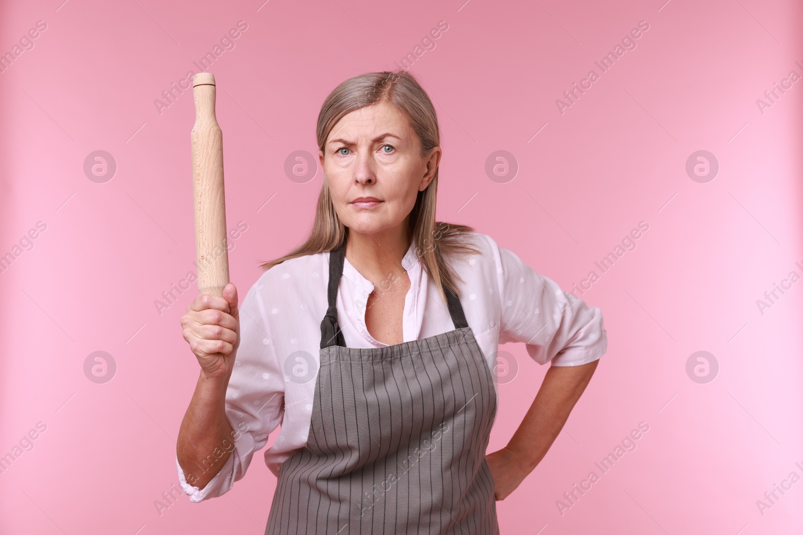 Photo of Woman with rolling pin on pink background