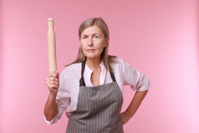 Photo of Woman with rolling pin on pink background