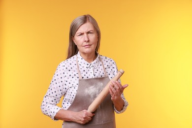 Photo of Woman with rolling pin on yellow background