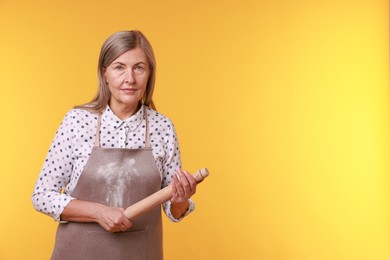 Photo of Woman with rolling pin on yellow background. Space for text