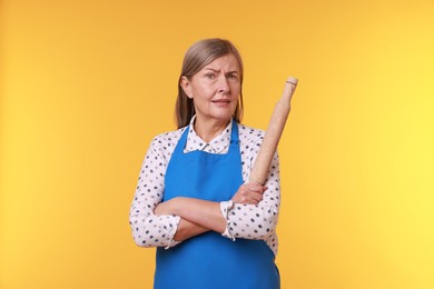 Photo of Woman with rolling pin on yellow background