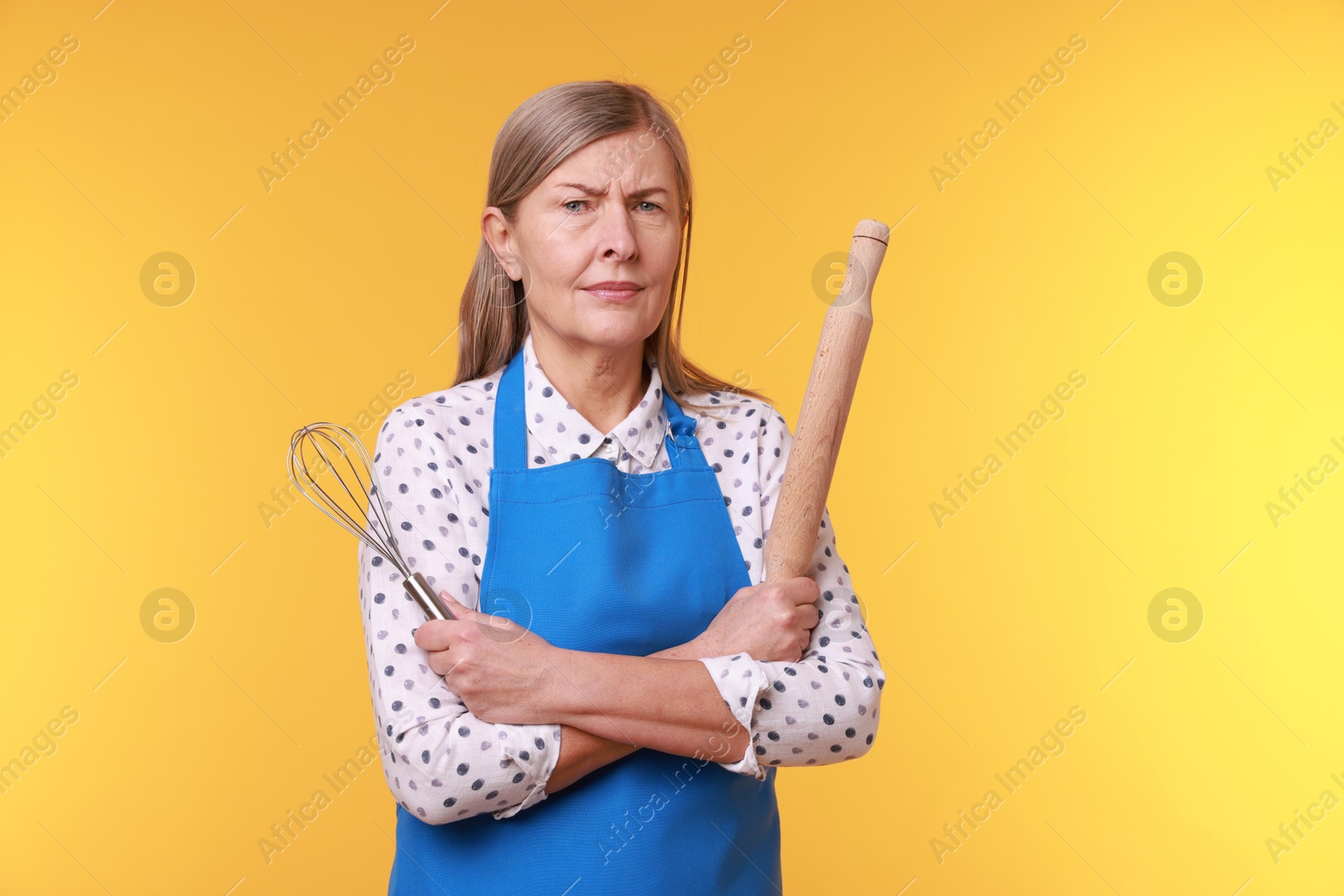 Photo of Woman with rolling pin on yellow background