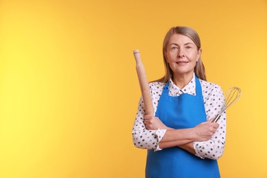 Photo of Woman with rolling pin and whisk on yellow background. Space for text