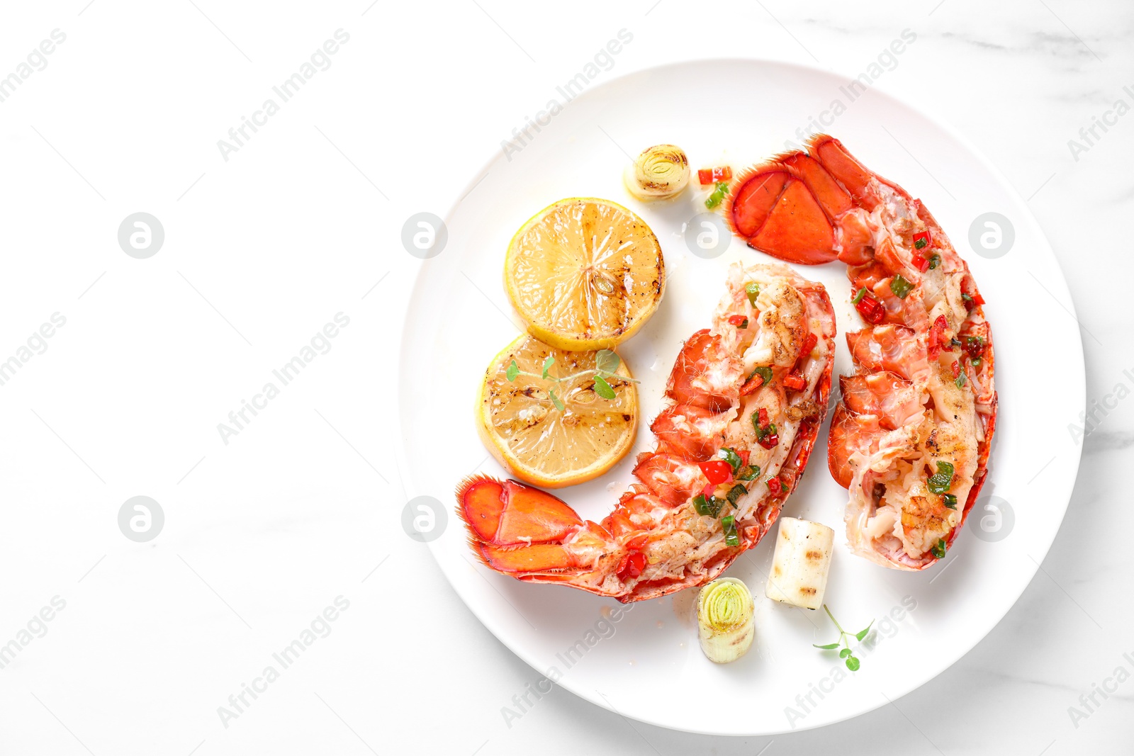 Photo of Delicious lobster tails with lemon, microgreens and green onion on white table, top view. Space for text