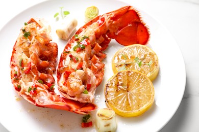 Photo of Delicious lobster tails with lemon, microgreens and green onion on white table, closeup