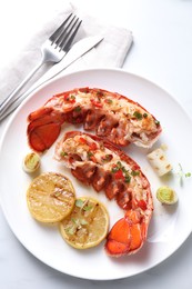 Photo of Delicious lobster tails with lemon, microgreens and green onion on white table, top view