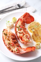 Delicious lobster tails with lemon, microgreens and green onion on white table, closeup