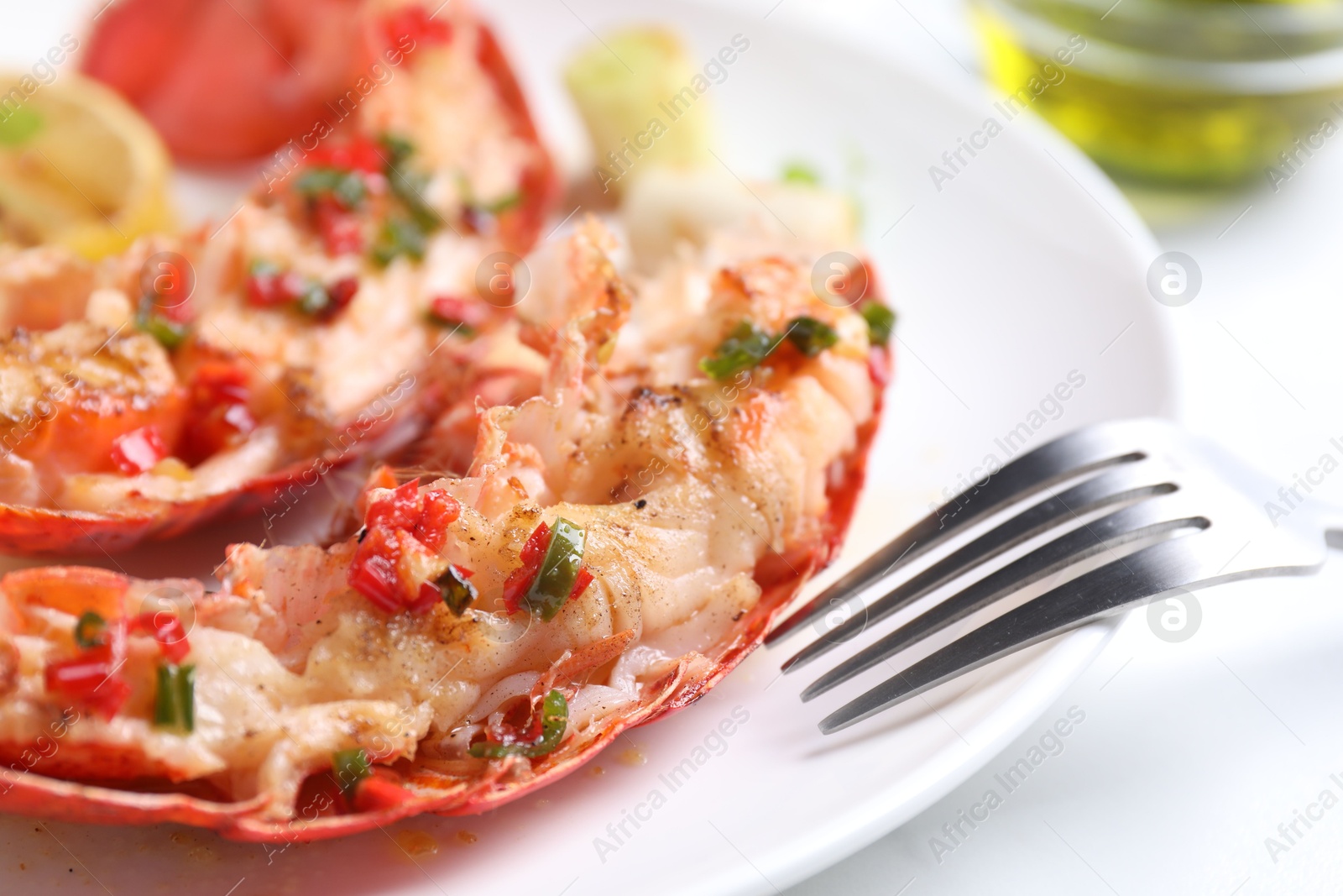 Photo of Delicious lobster tails with green onion on white table, closeup