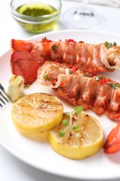 Photo of Delicious lobster tails with lemon, microgreens and green onion on white table, closeup