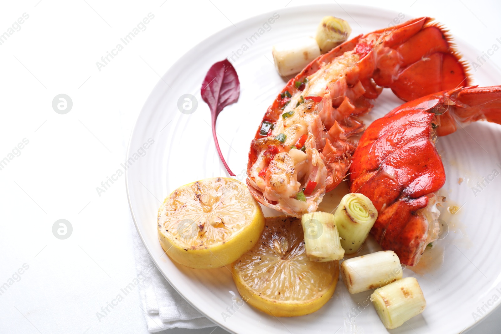 Photo of Delicious lobster tails with lemon and green onion on white table, closeup. Space for text