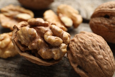 Photo of Fresh walnuts with shells on table, closeup