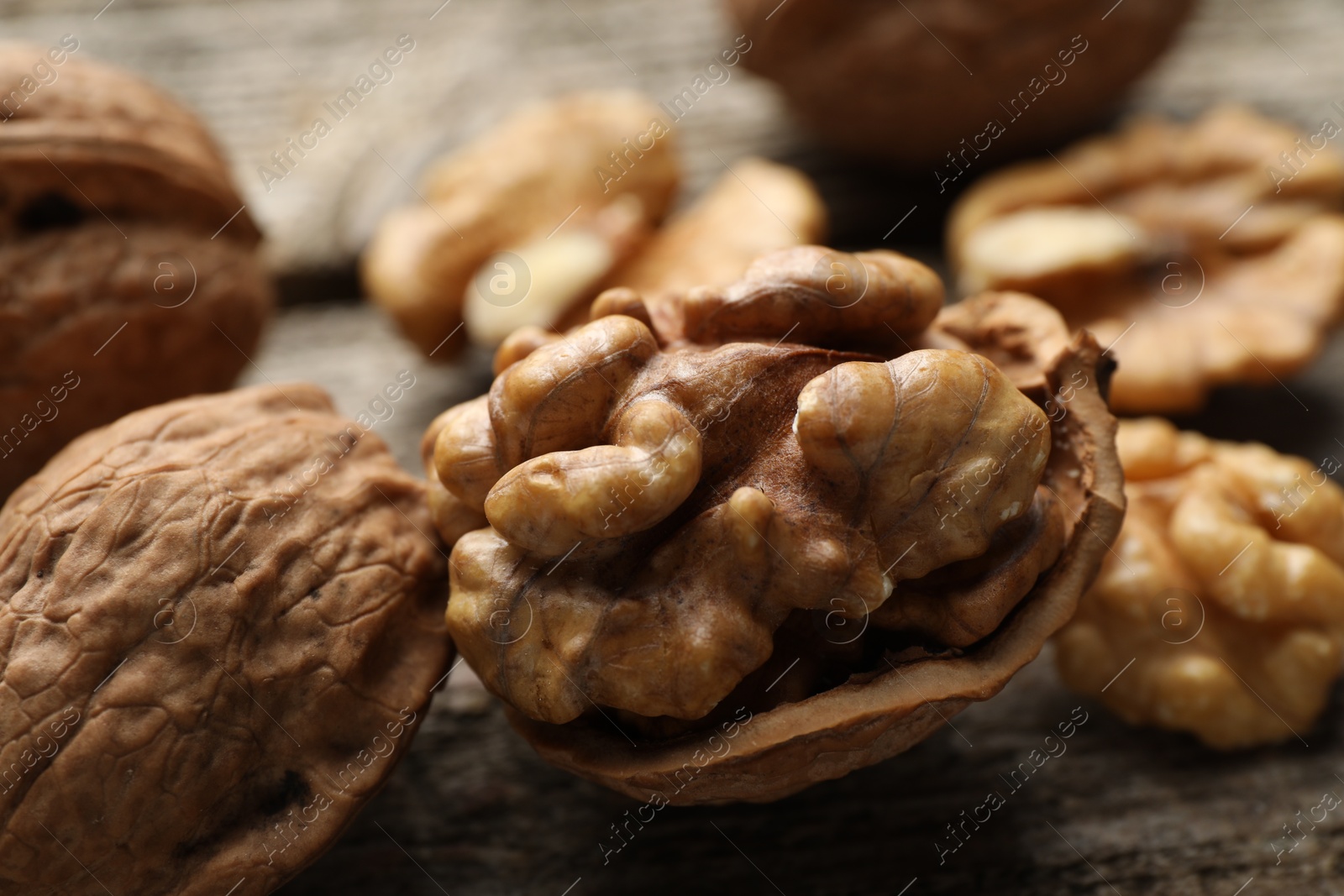 Photo of Fresh walnuts with shells on table, closeup