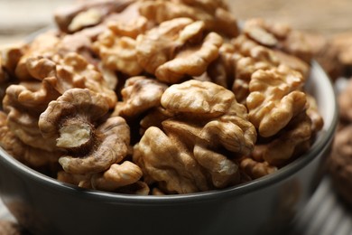 Photo of Fresh walnuts in bowl on table, closeup