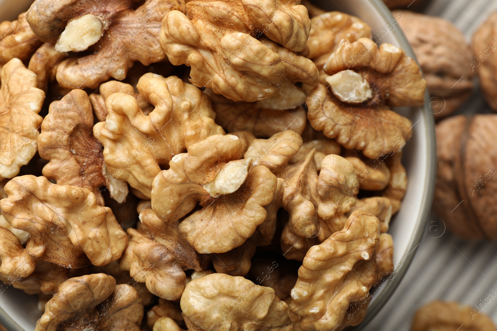 Photo of Fresh walnuts in bowl on table, top view