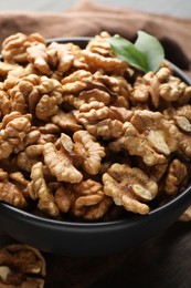 Photo of Fresh ripe walnuts in bowl on table, closeup