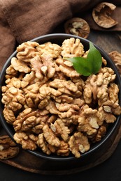 Photo of Fresh ripe walnuts in bowl on table, top view