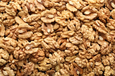 Photo of Pile of fresh ripe walnuts as background, top view