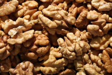 Photo of Pile of fresh ripe walnuts as background, top view