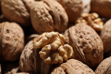 Photo of Fresh walnuts in shells and shelled one as background, closeup