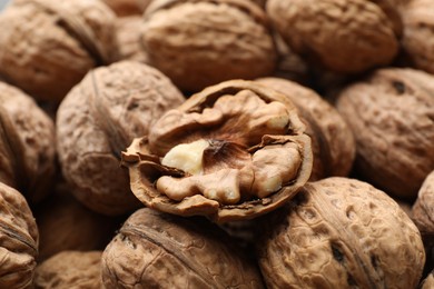 Photo of Fresh walnuts in shells as background, closeup