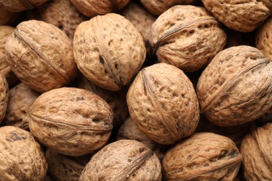 Photo of Fresh walnuts in shells as background, top view