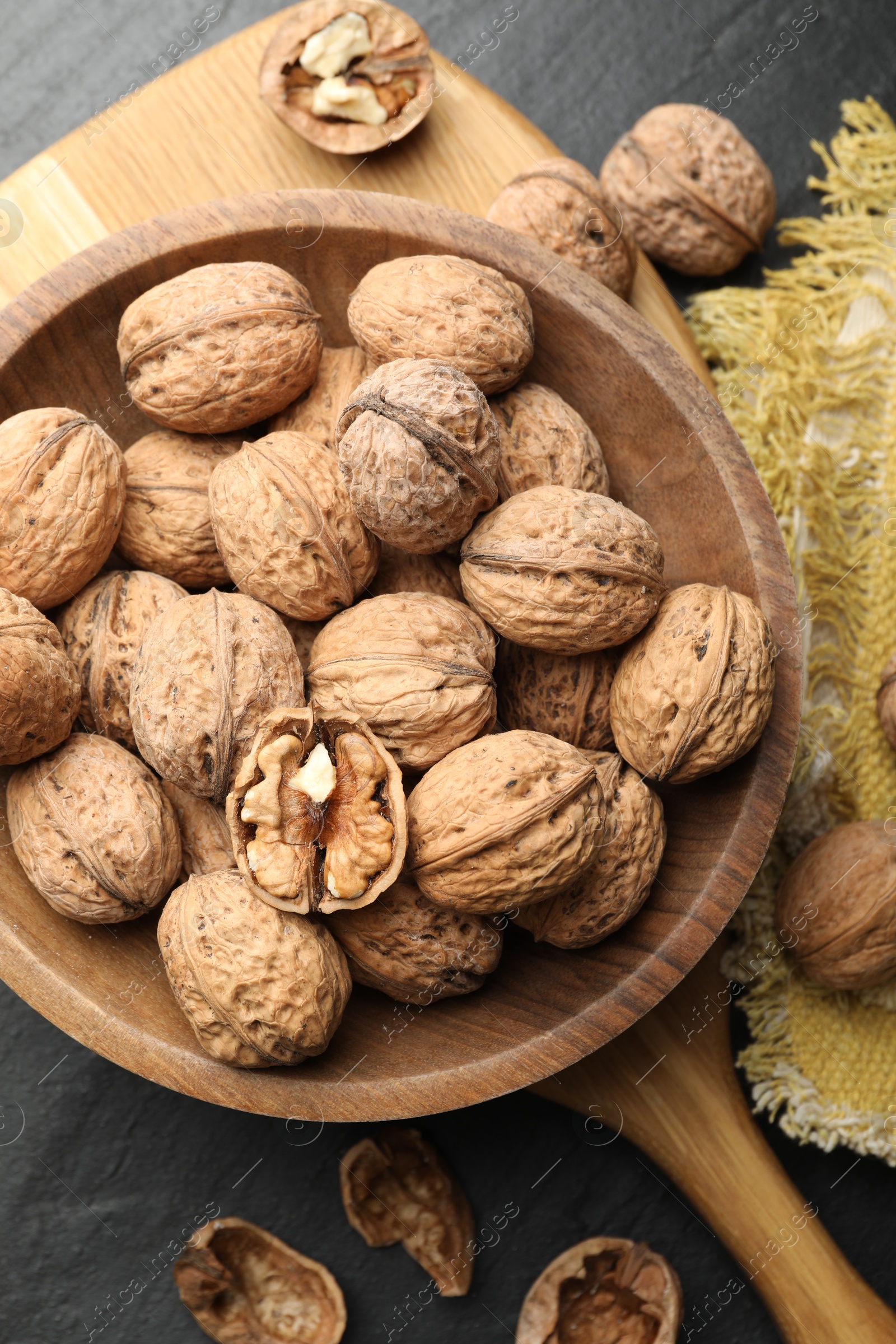 Photo of Fresh ripe walnuts in shells on black table, flat lay