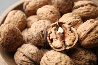 Photo of Bowl of fresh ripe walnuts in shells, closeup