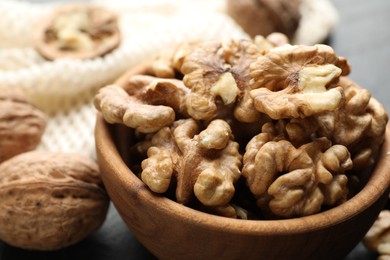 Photo of Fresh ripe walnuts in bowl on table, closeup