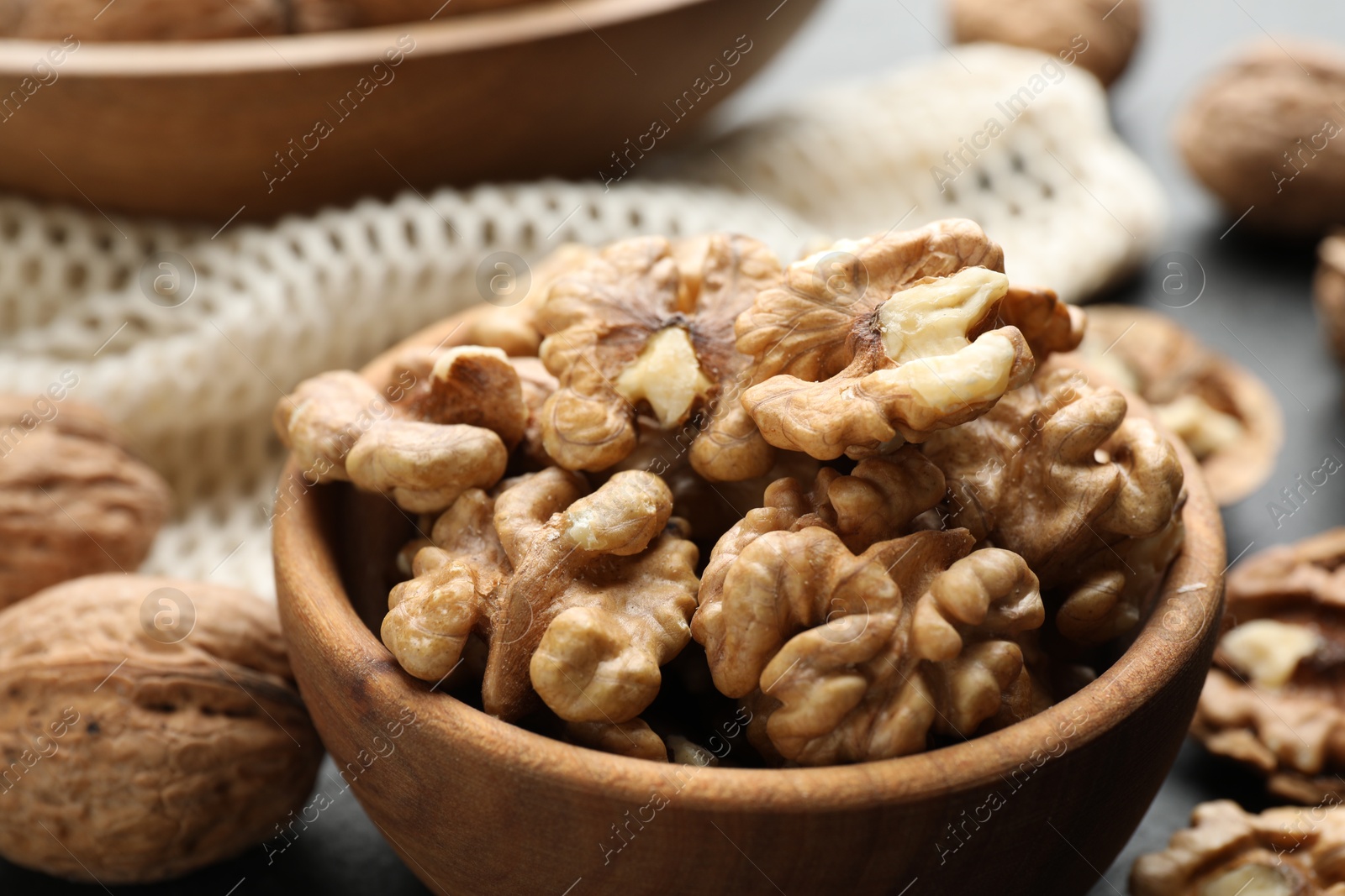 Photo of Fresh ripe walnuts in bowl on table, closeup